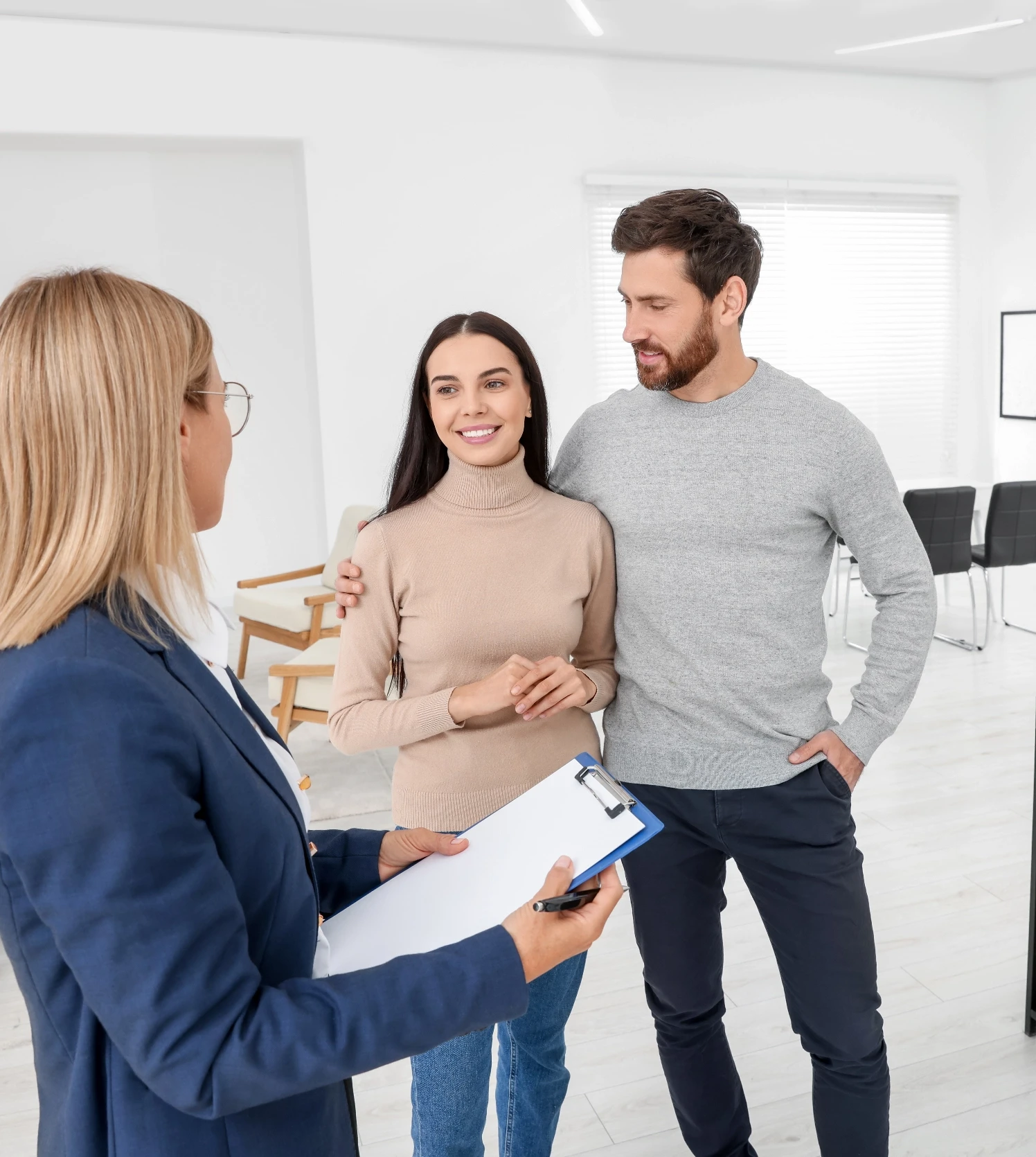 Immobilienmaklerin berät ein junges Paar bei einer Wohnungsbesichtigung